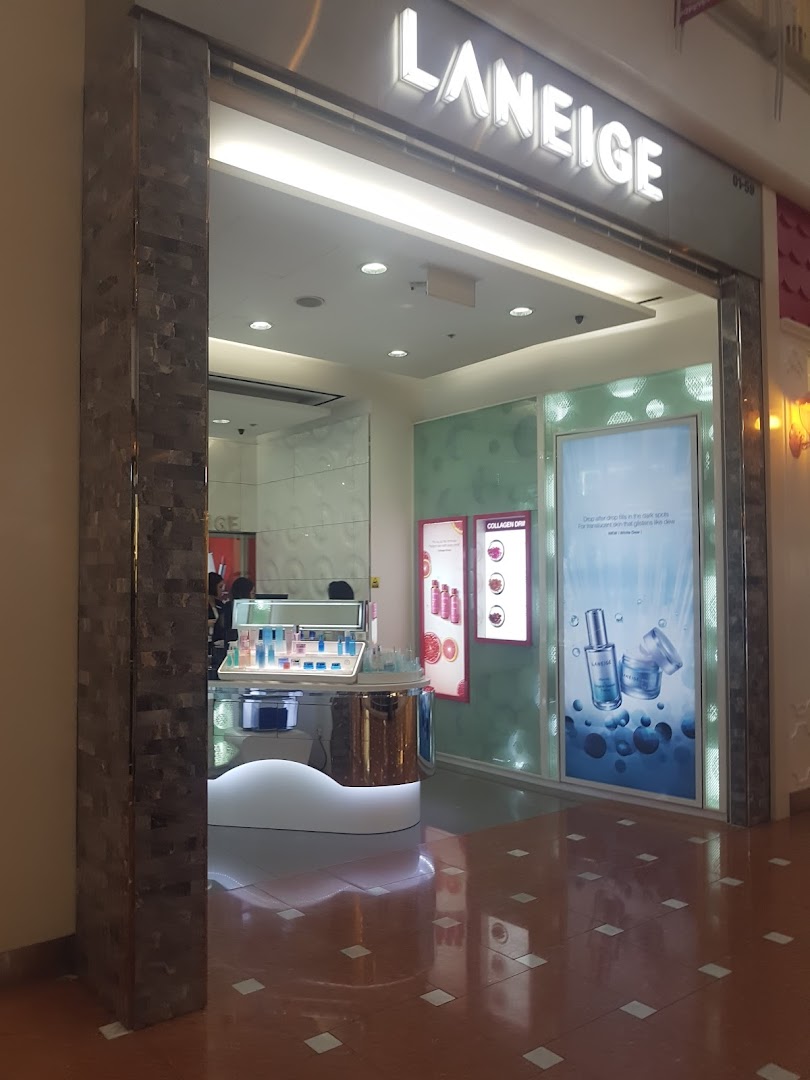The illuminated entrance of a LANEIGE beauty store, showcasing skincare products and promotional displays.