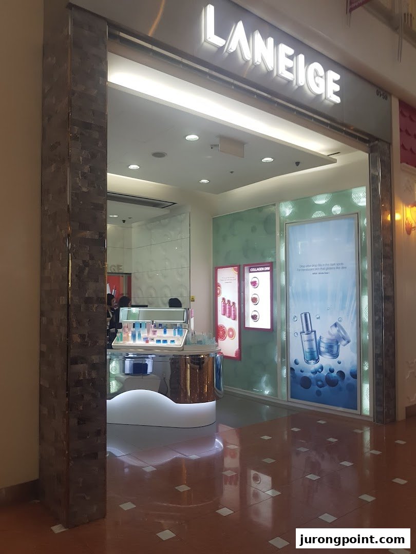 The illuminated entrance of a LANEIGE beauty store, showcasing skincare products and promotional displays.