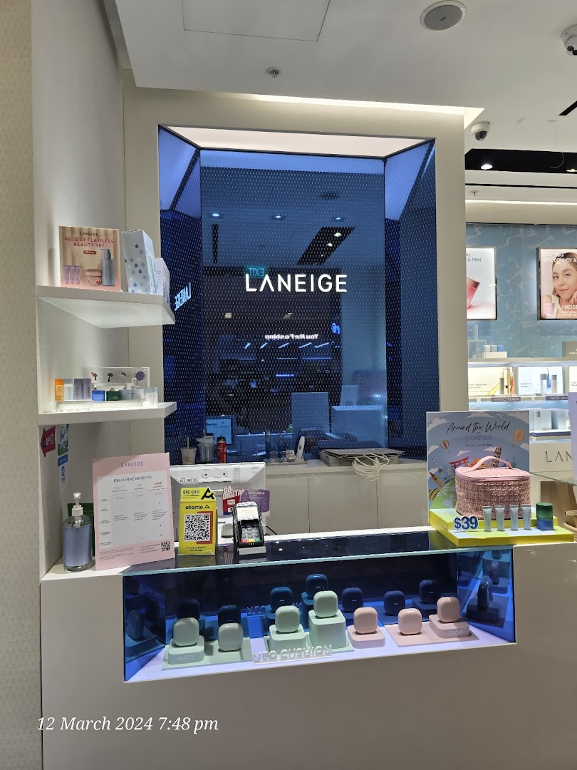 A brightly lit LANEIGE store counter showcasing skincare products, promotional displays, and payment options.