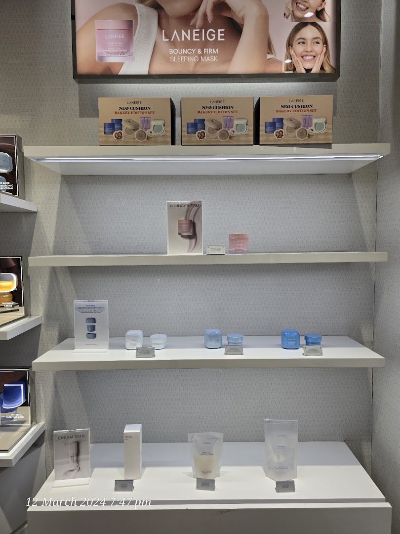 LANEIGE skincare products displayed on white shelves with promotional signage and product sets.