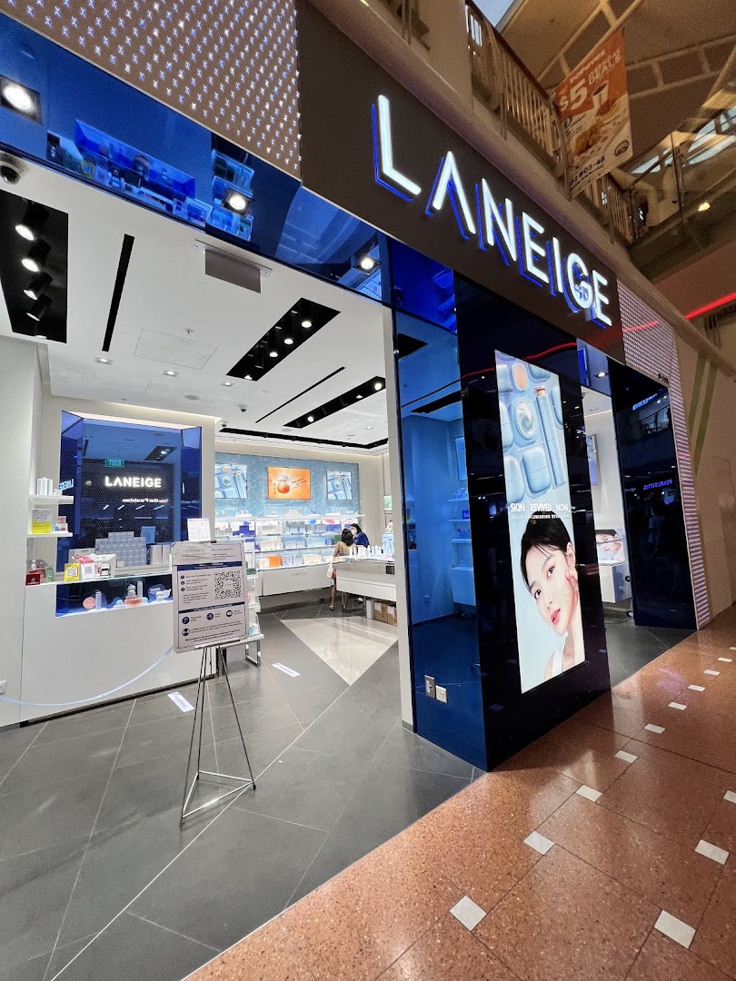 The brightly lit LANEIGE shop entrance features a prominent sign, product displays, and a large digital screen.