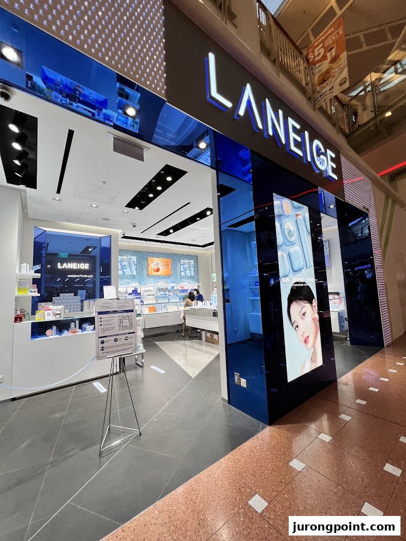 The brightly lit LANEIGE shop entrance features a prominent sign, product displays, and a large digital screen.