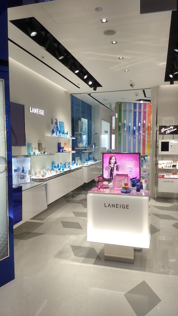 An interior view of the Laneige beauty store, showcasing skincare products on illuminated displays and a central promotional counter.