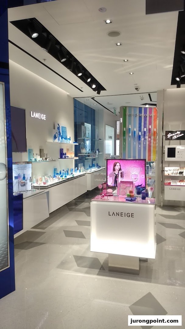 An interior view of the Laneige beauty store, showcasing skincare products on illuminated displays and a central promotional counter.
