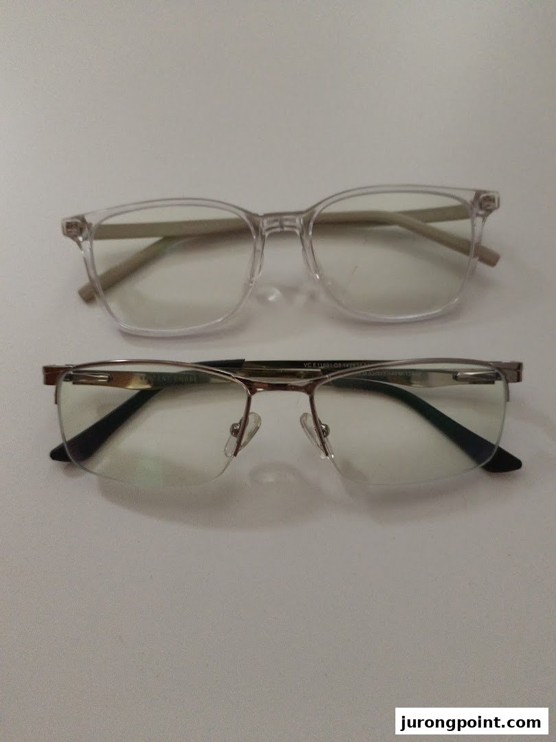 Two pairs of stylish eyeglasses, one clear-framed and one semi-rimless, displayed on a white surface.
