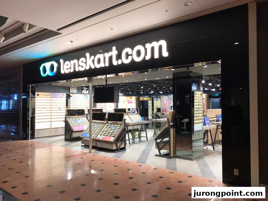 The Lenskart shop front features a prominent black facade with its illuminated logo and a clear view of eyewear displays inside.