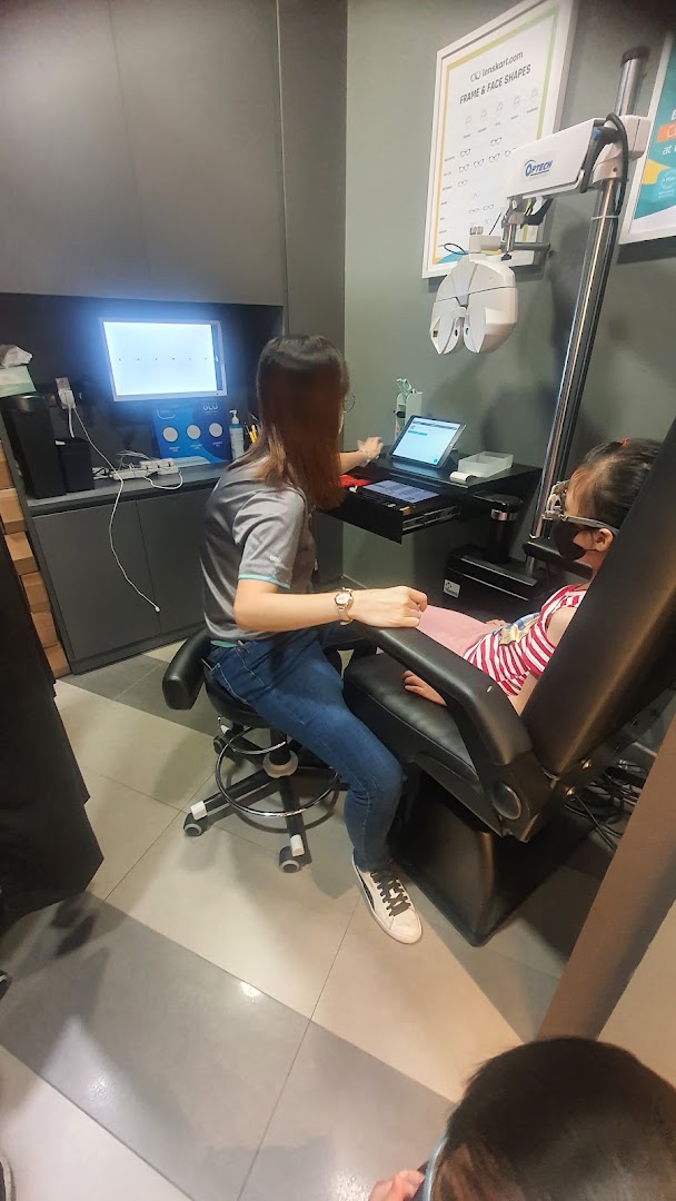 A Lenskart staff member performs an eye examination on a child using advanced optical equipment.