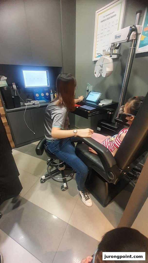 A Lenskart staff member performs an eye examination on a child using advanced optical equipment.