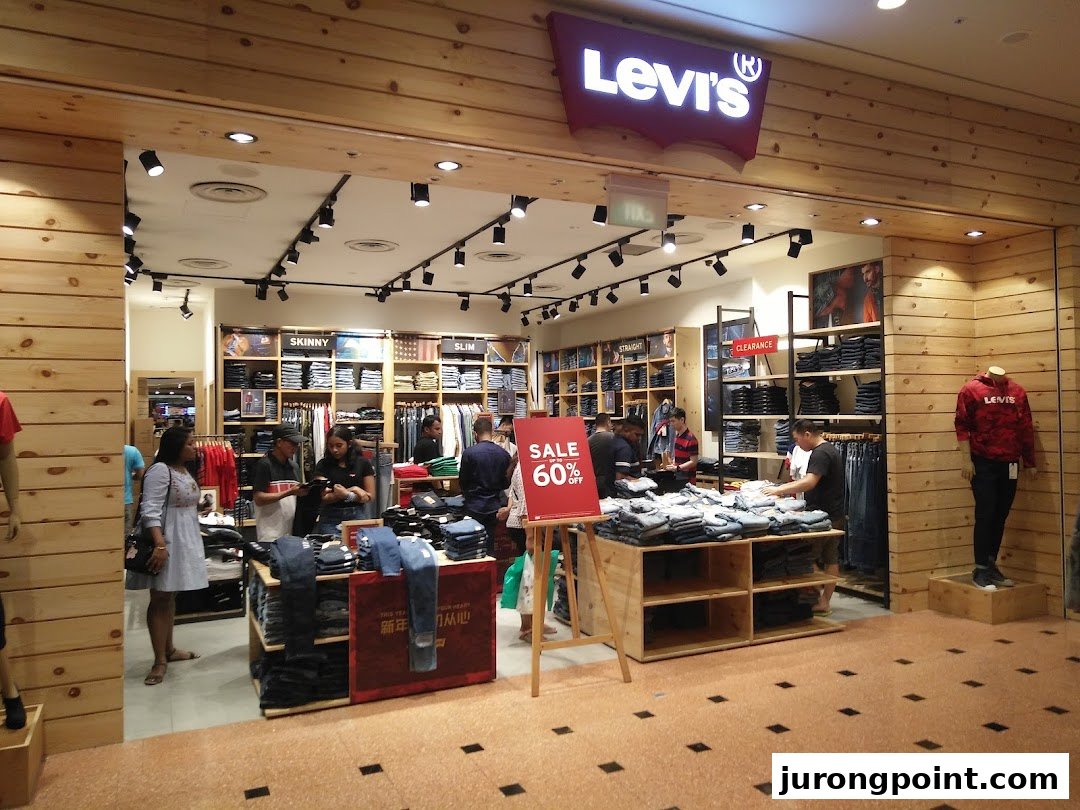 Customers browse denim and apparel inside a well-lit Levi's store featuring a prominent sale.