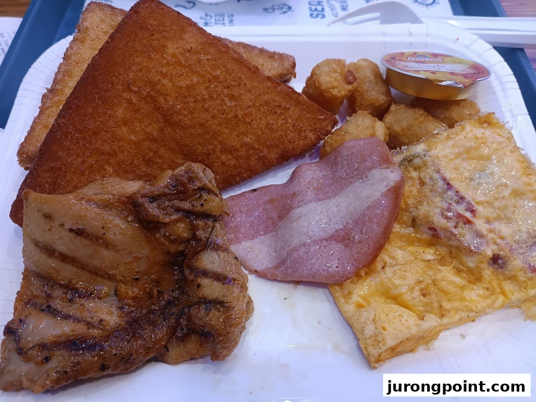 A hearty breakfast platter featuring grilled chicken, bacon, omelet, hash browns, and toast on a white tray.