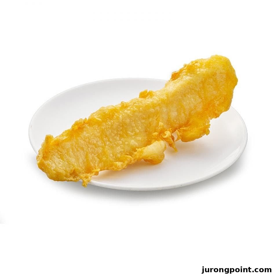 A golden-brown piece of crispy, battered fish on a white plate, ready to be enjoyed.