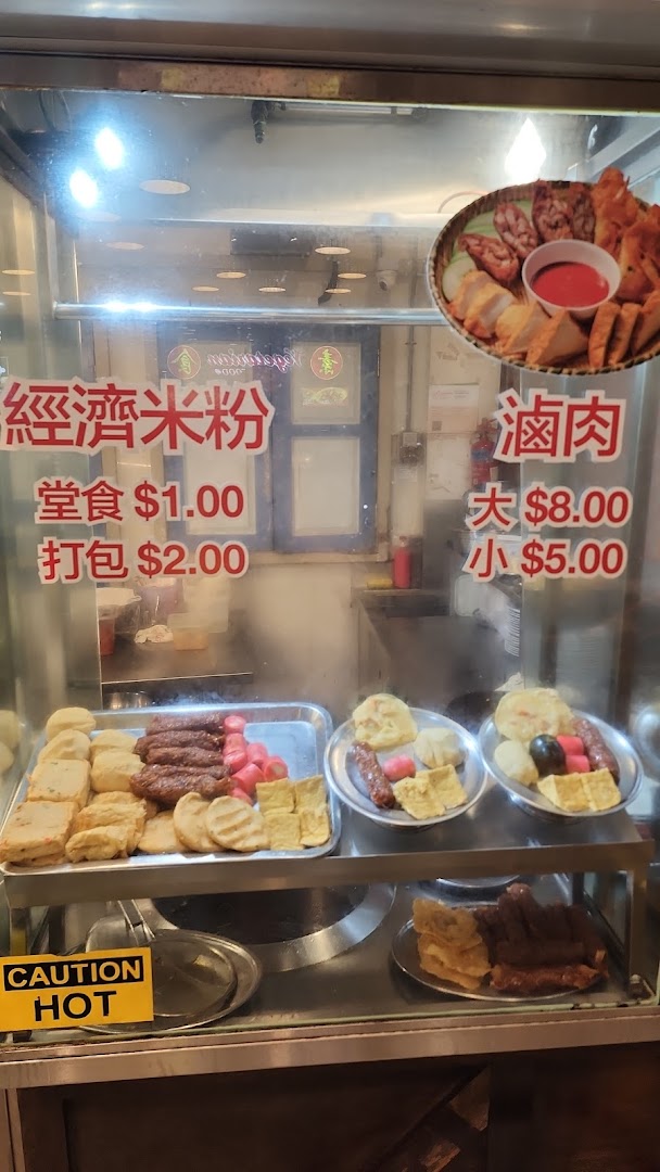 A food stall display case showcasing various cooked items and their prices.