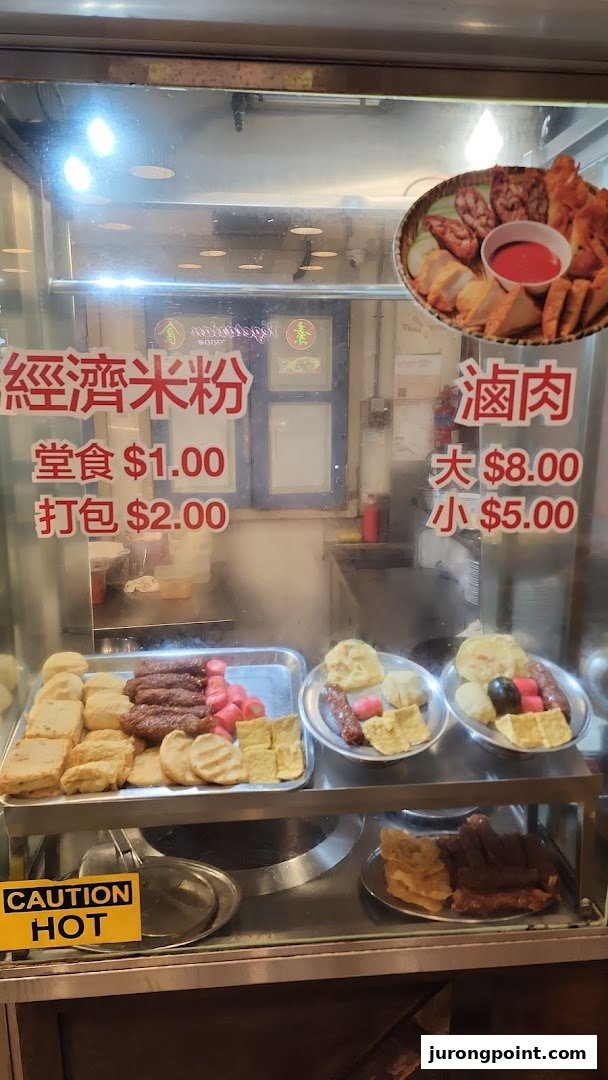 A food stall display case showcasing various cooked items and their prices.