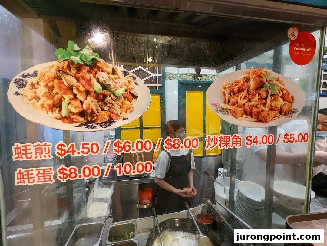 A hawker stall's menu board displaying popular local dishes like Oyster Omelette and Fried Radish Cake with prices.