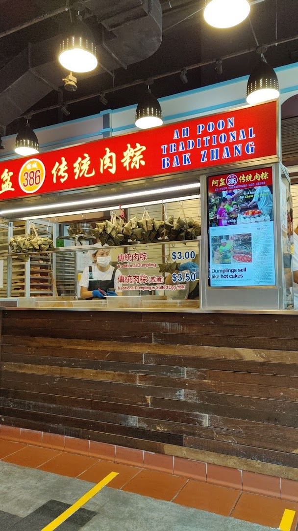 A food stall named Ah Poon Traditional Bak Zhang, featuring a staff member and traditional dumplings.