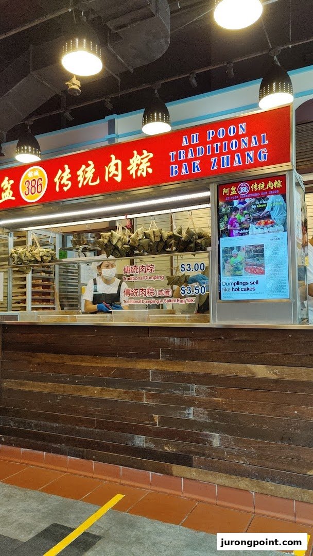 A food stall named Ah Poon Traditional Bak Zhang, featuring a staff member and traditional dumplings.