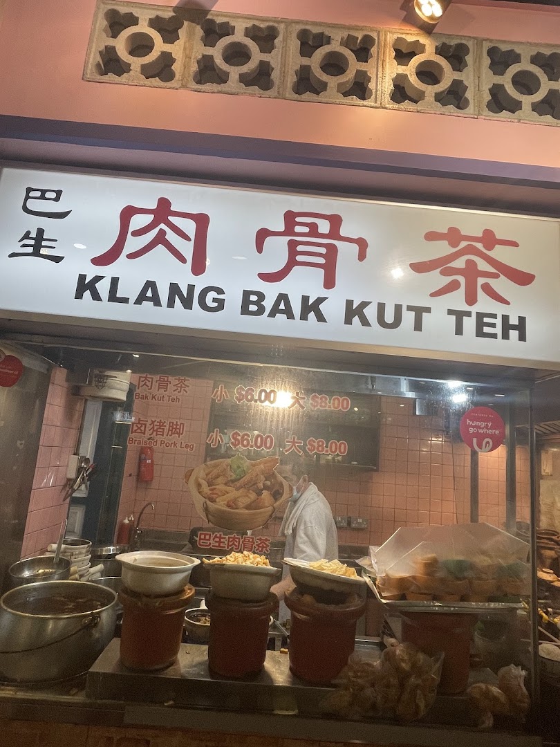 A vibrant shop front displaying Klang Bak Kut Teh and Braised Pork Leg menu items with prices.