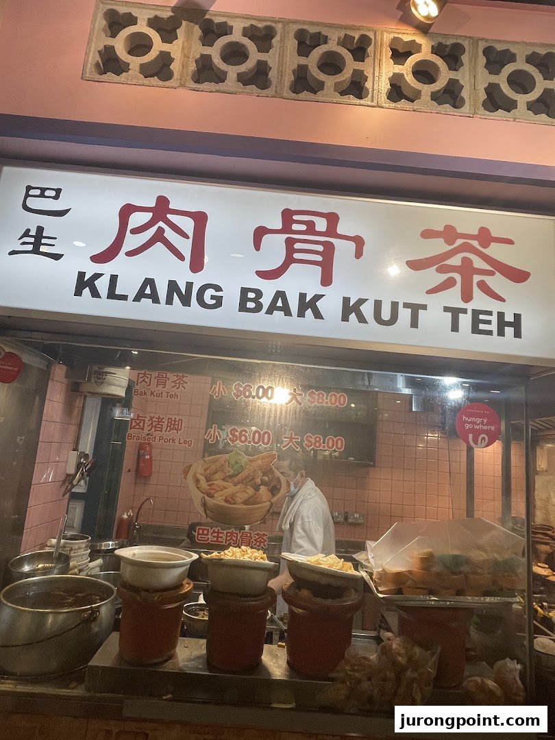 A vibrant shop front displaying Klang Bak Kut Teh and Braised Pork Leg menu items with prices.