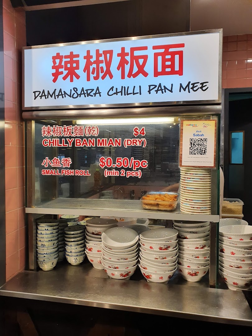 A food stall counter at Malaysia Boleh! featuring Damansara Chilli Pan Mee and stacked bowls.