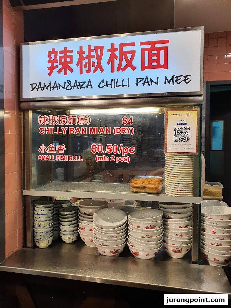 A food stall counter at Malaysia Boleh! featuring Damansara Chilli Pan Mee and stacked bowls.