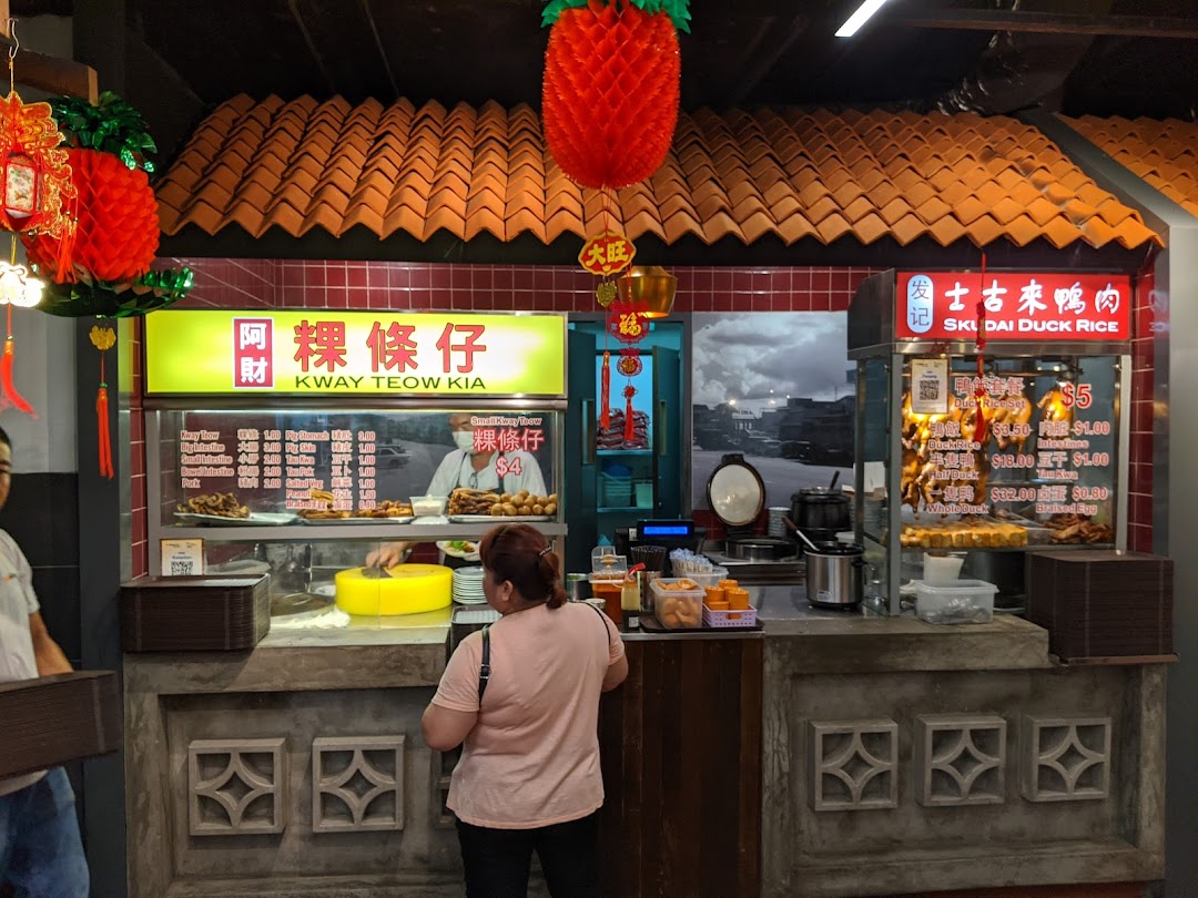 A vibrant food stall at Malaysia Boleh! food court, featuring Kway Teow Kia and Skudai Duck Rice menus.
