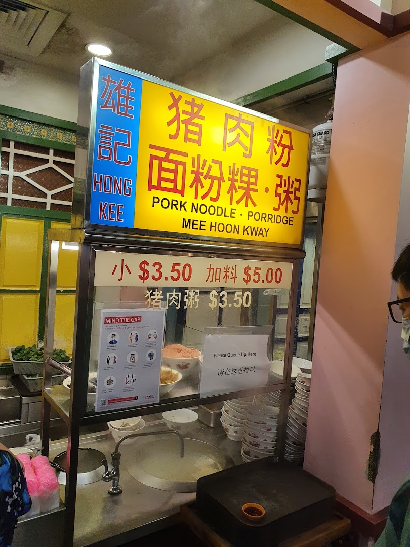 A food stall's menu board displaying traditional noodle and porridge dishes with prices.
