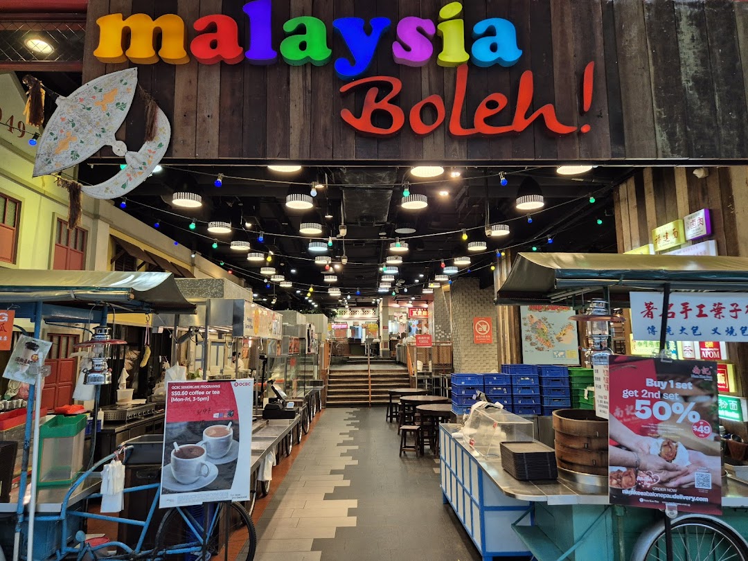 The vibrant entrance to Malaysia Boleh! food court, showcasing diverse Malaysian street food stalls.