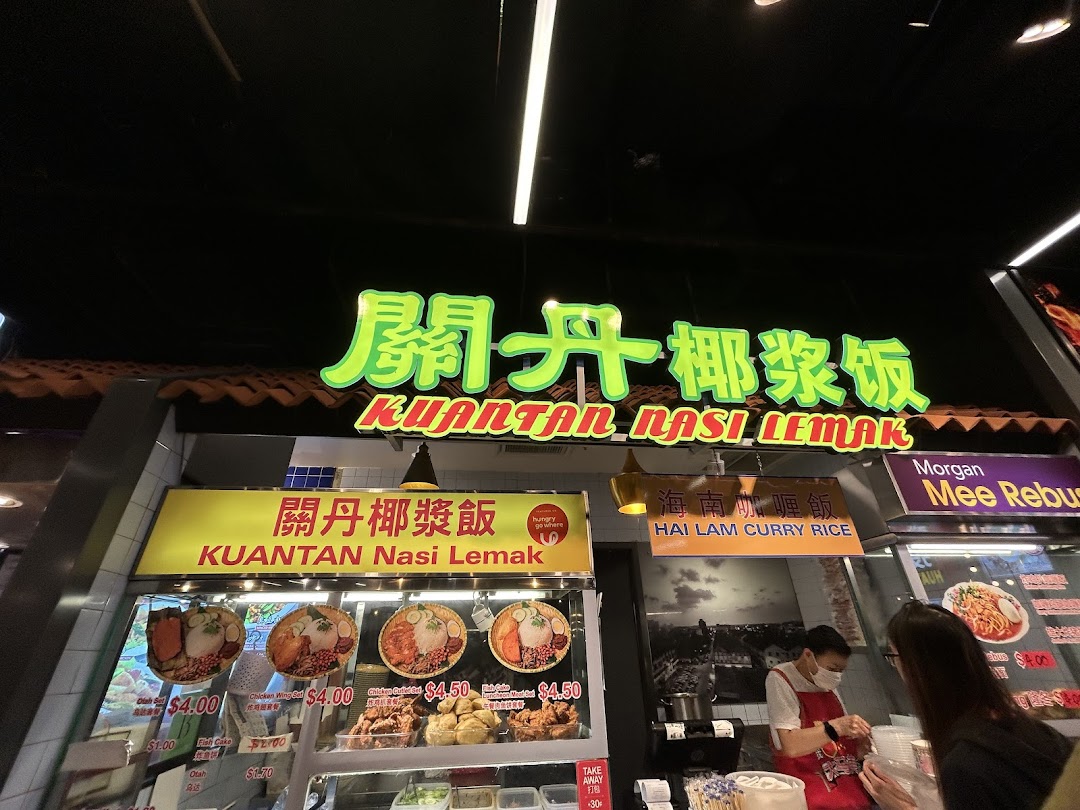 The vibrant front of Kuantan Nasi Lemak stall, showcasing delicious Malaysian dishes and a busy counter.