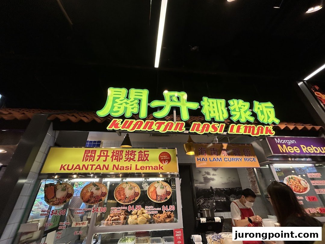 The vibrant front of Kuantan Nasi Lemak stall, showcasing delicious Malaysian dishes and a busy counter.
