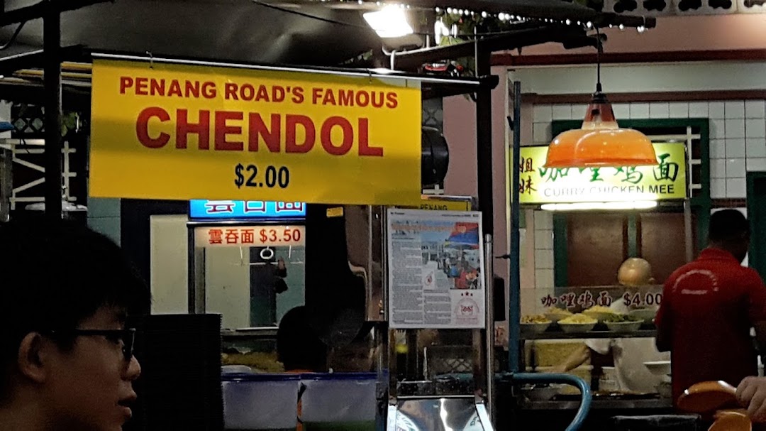 A vibrant food stall showcasing popular Malaysian dishes like Chendol, Wonton Mee, and Curry Chicken Mee with prices.