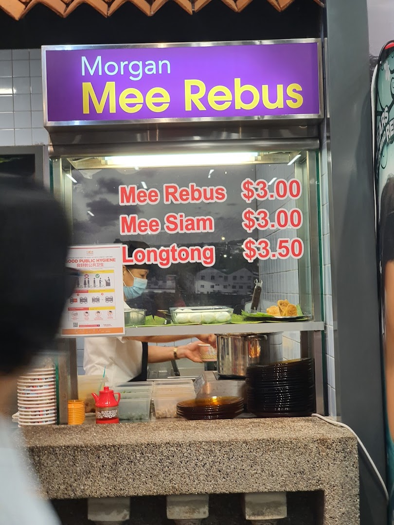 A food stall displaying its menu for Mee Rebus, Mee Siam, and Longtong with prices.