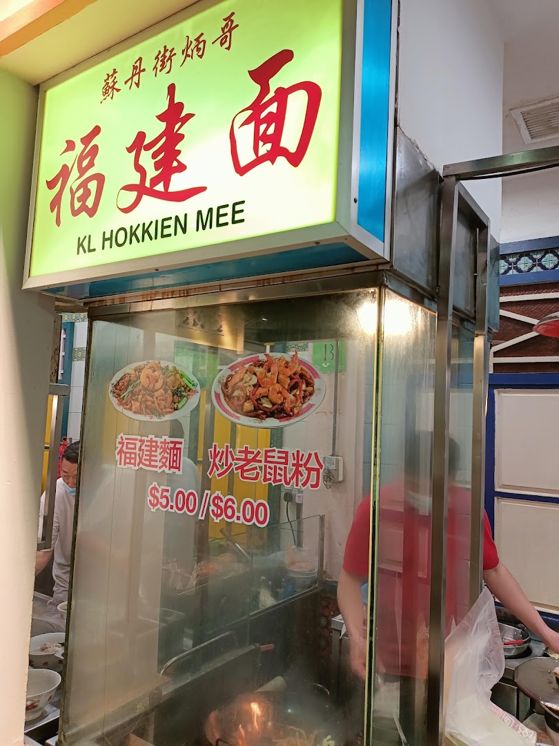 A food stall sign for KL Hokkien Mee, displaying dishes and prices.