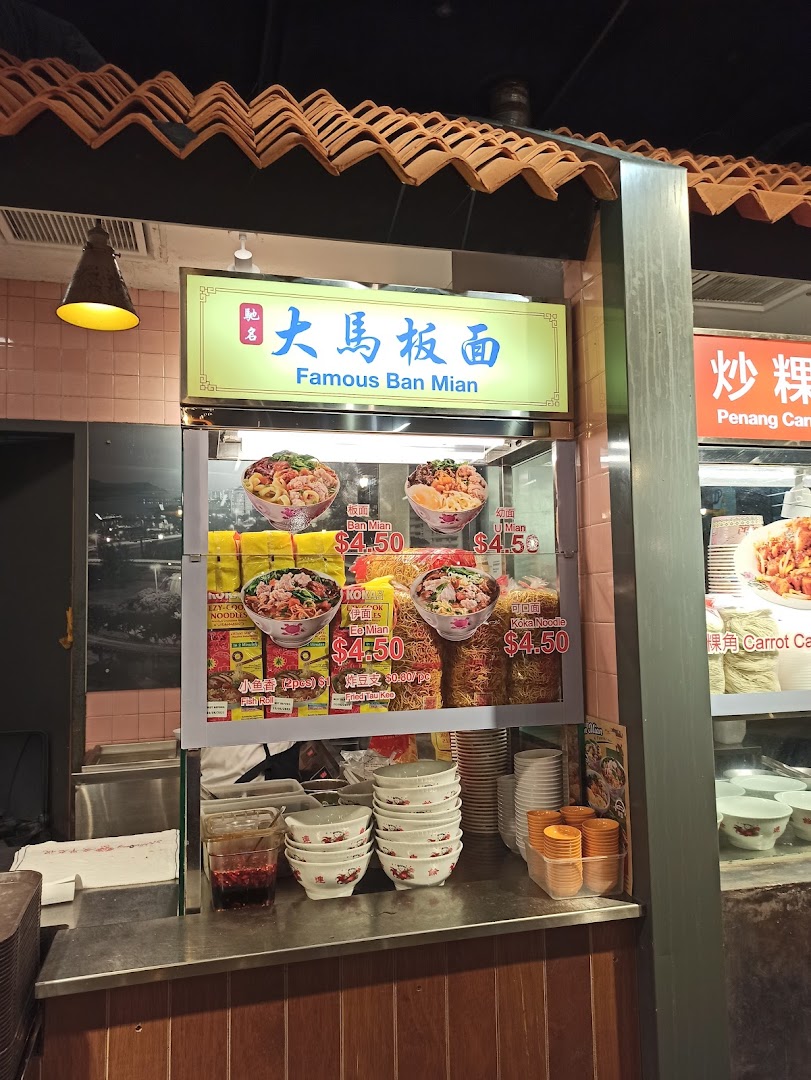 A bustling food stall at Malaysia Boleh! serving Famous Ban Mian noodles with various toppings.