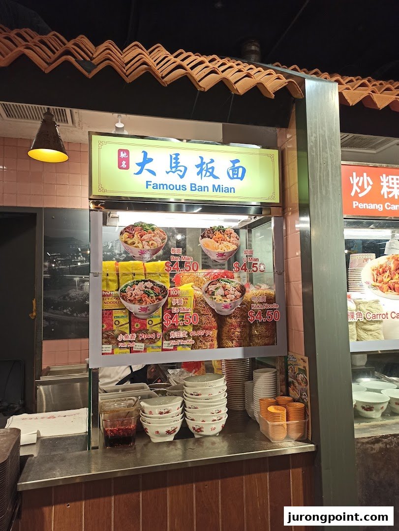A bustling food stall at Malaysia Boleh! serving Famous Ban Mian noodles with various toppings.