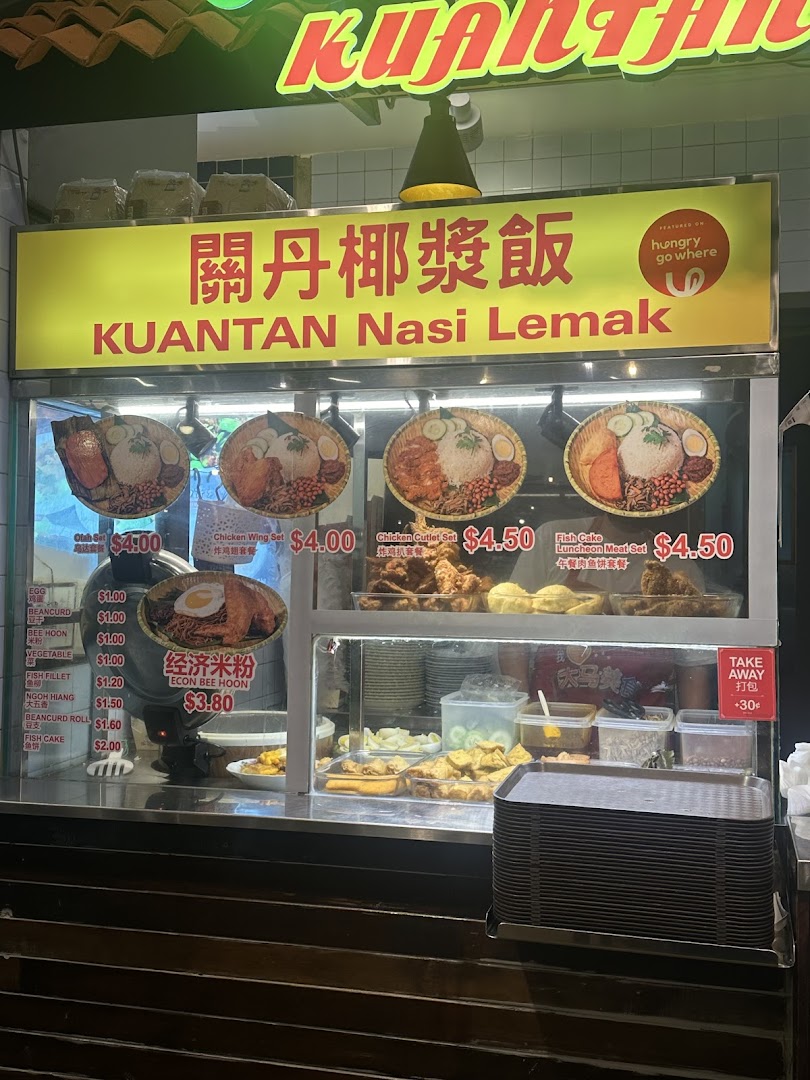 A vibrant food stall displaying various Nasi Lemak sets and Malaysian side dishes with prices.