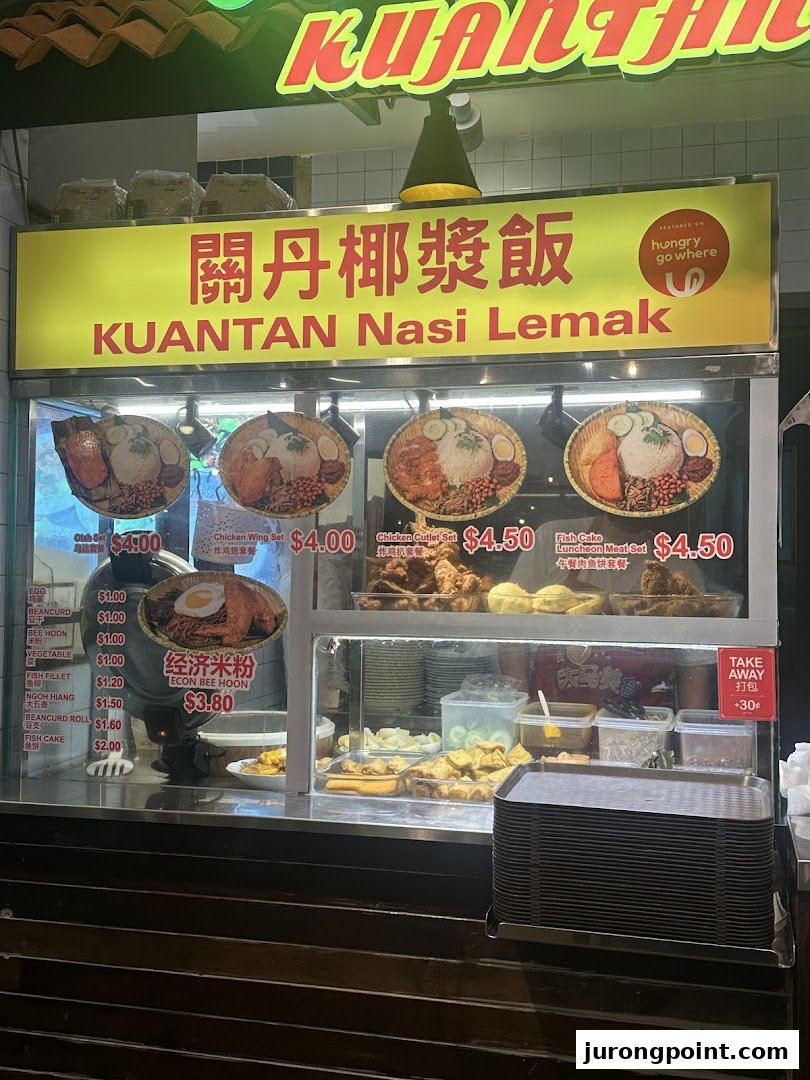 A vibrant food stall displaying various Nasi Lemak sets and Malaysian side dishes with prices.