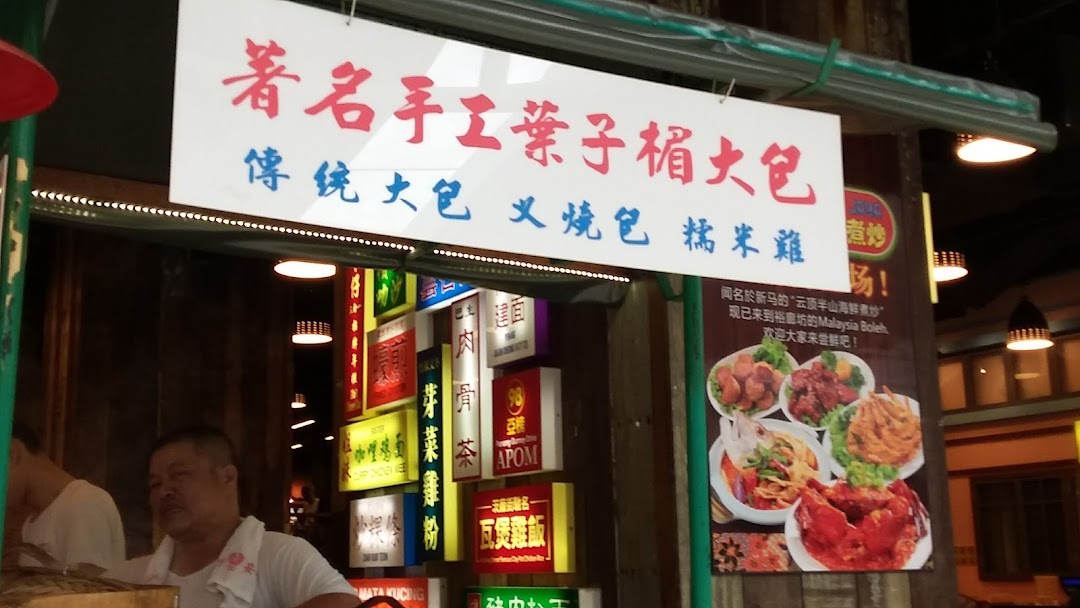 A vibrant shop front for 'Malaysia Boleh!' featuring a sign for traditional paus and other Malaysian dishes.