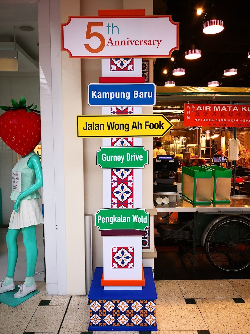 Vibrant interior view of Malaysia Boleh! with a decorative signpost and a unique strawberry mannequin.