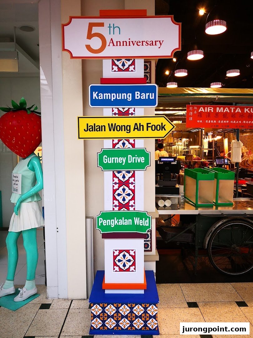 Vibrant interior view of Malaysia Boleh! with a decorative signpost and a unique strawberry mannequin.