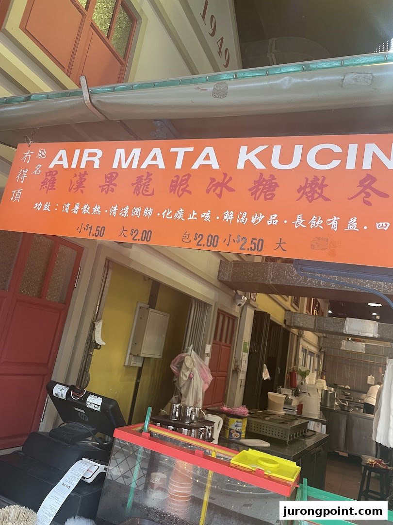 A vibrant orange sign displaying prices and benefits for traditional Malaysian drinks.