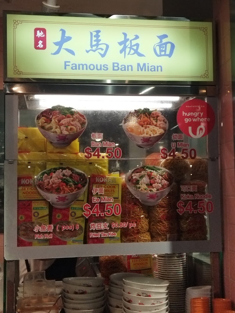 A display case showcasing various noodle dishes and side items with their prices.