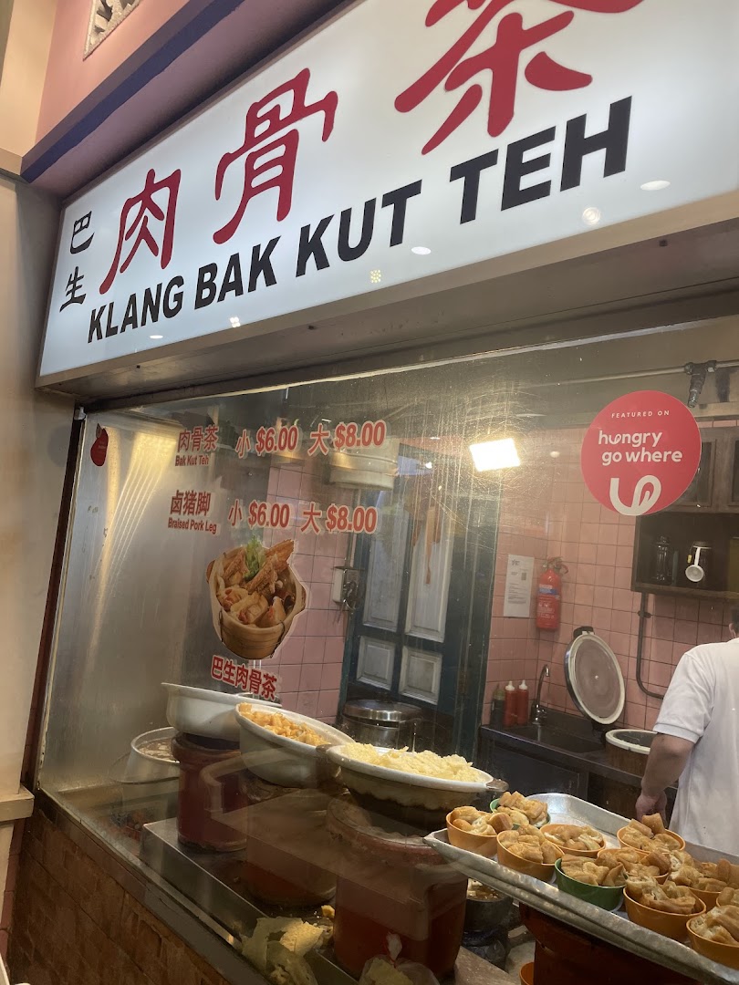A food stall's window displaying Bak Kut Teh and Braised Pork Leg with prices.