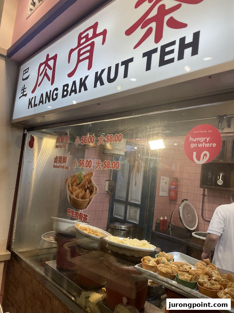 A food stall's window displaying Bak Kut Teh and Braised Pork Leg with prices.