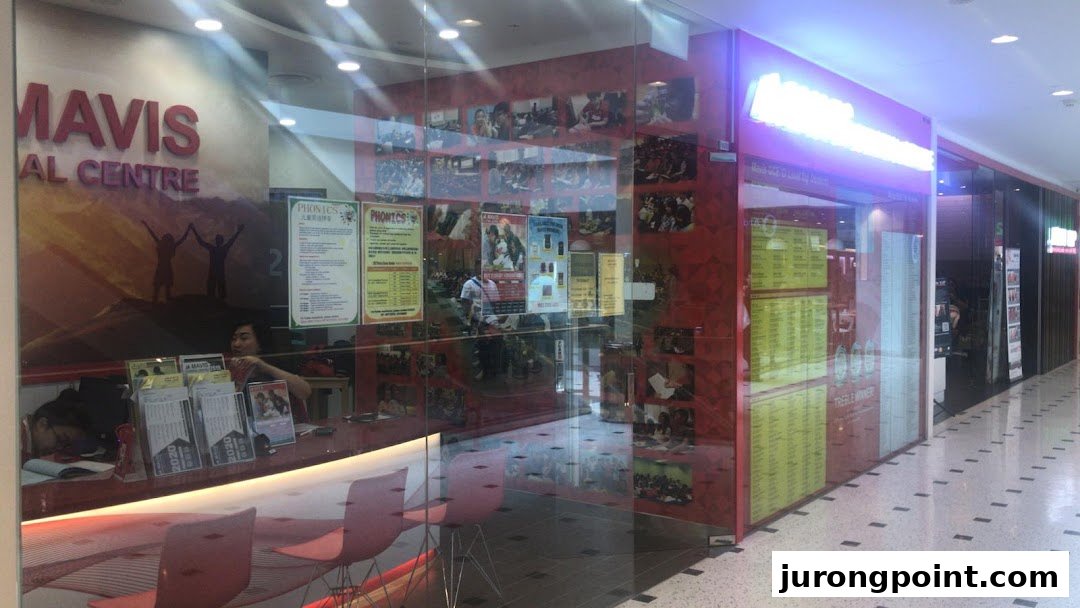 The glass shop front of Mavis Tutorial Centre, showcasing promotional materials and an interior view.
