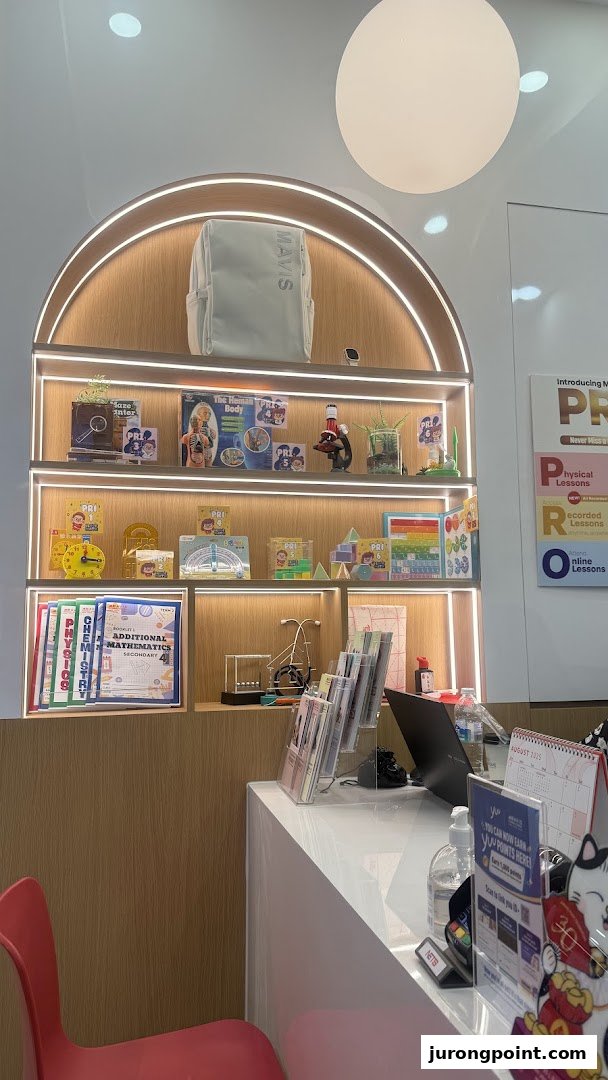 Interior view of Mavis Tutorial, showcasing educational materials on a brightly lit display shelf and a reception counter.
