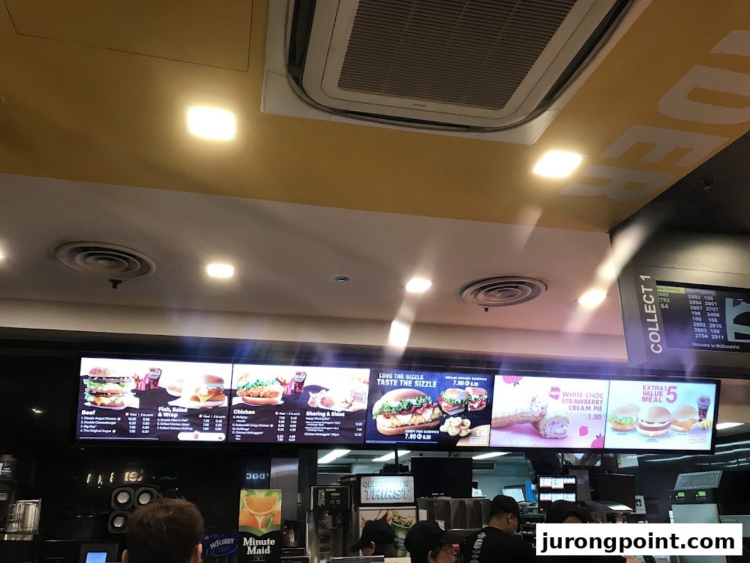 Digital menu boards at McDonald's displaying various food items, prices, and promotions.