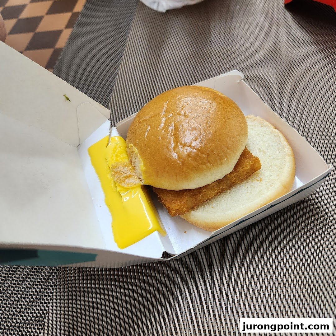 A McDonald's Filet-O-Fish sandwich with melted cheese in its open box.