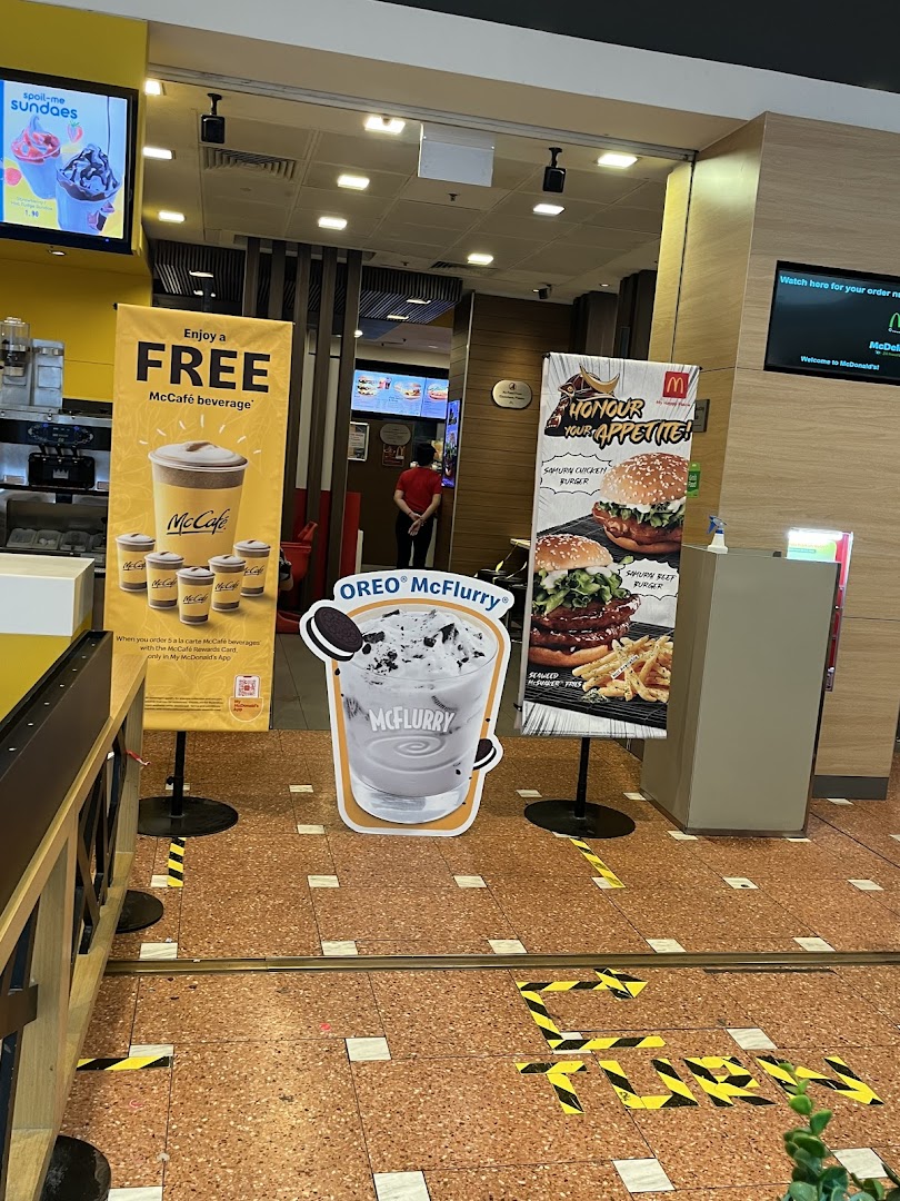 Entrance area of McDonald's featuring promotional displays for McCafé, McFlurry, and Samurai burgers.