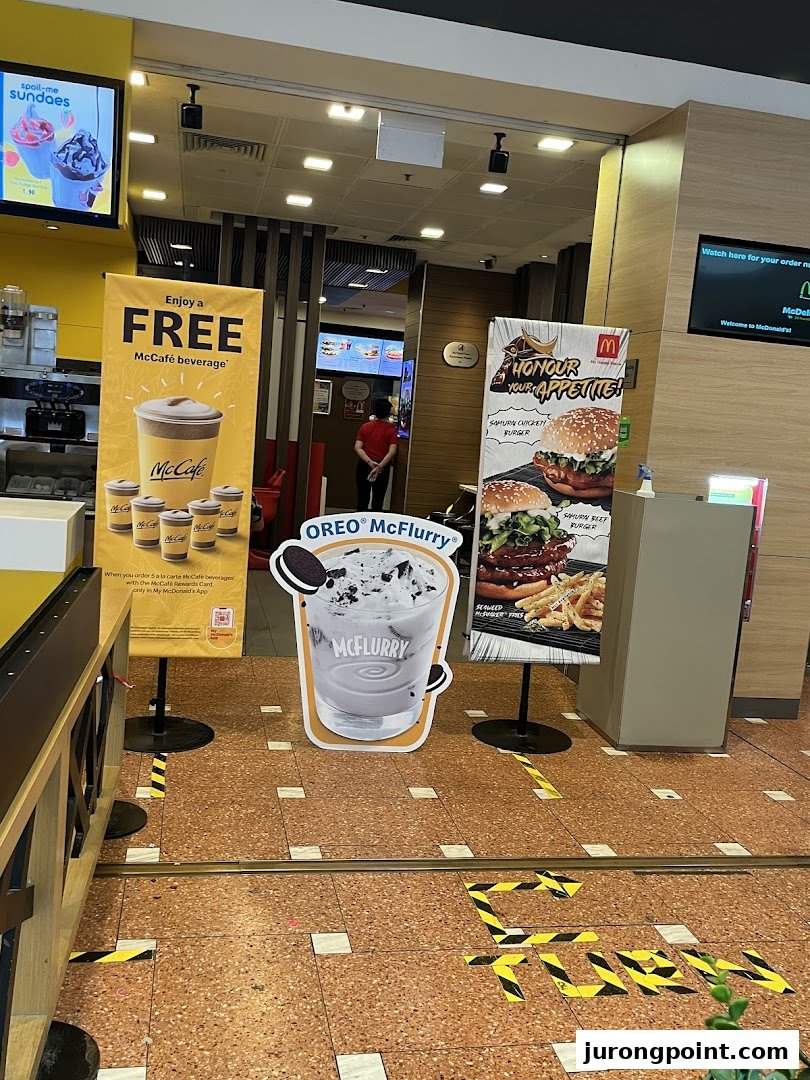 Entrance area of McDonald's featuring promotional displays for McCafé, McFlurry, and Samurai burgers.