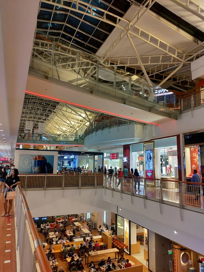 A multi-level shopping mall interior showcasing diverse shops, a bustling food court, and a McDonald's outlet.